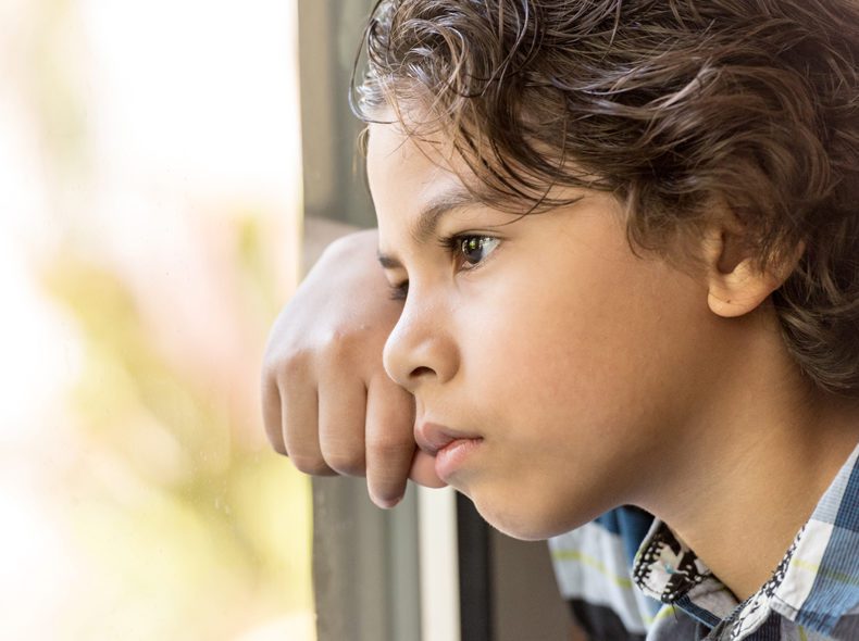 boy looking out the window pensively