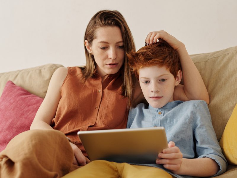 Woman and boy watching tablet computer