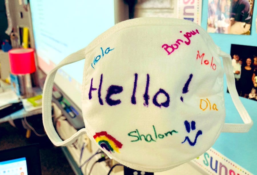 Students decorate a mark with the word "hello" in colorful ways in multiple languages.