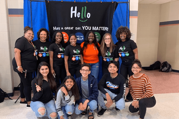 A SAVE Promise Club stands in front of a banner that says "Hello, Have a great Day! You Matter!