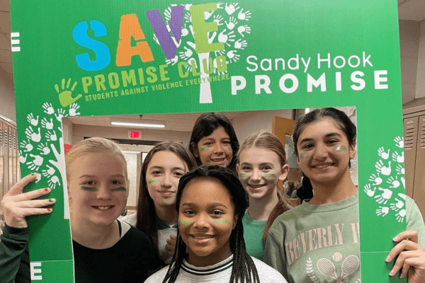 Students holding SAVE Promise Club and Sandy Hook Promise sign